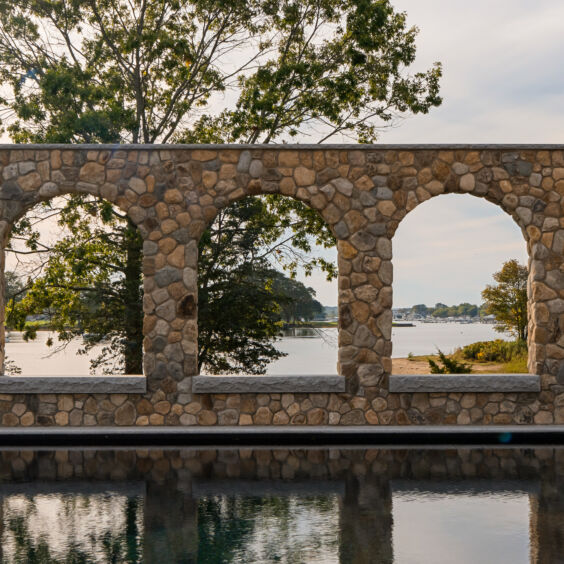 Stoneyard Kems Beverly | Outdoor | Stone Arch Wall Close Close-up of Stoneyard Boston Blend Round 140 stone arch colonnade framing the Beverly MA waterfront. Photo by Matt McNamara.