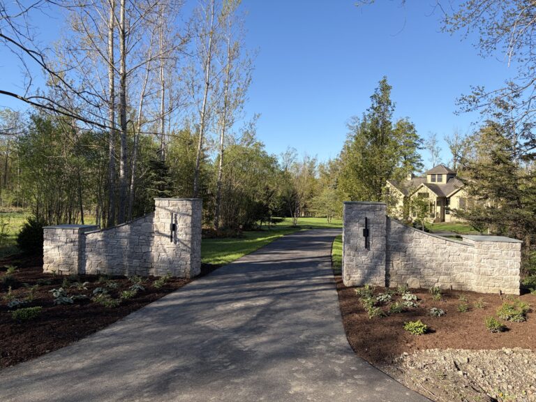 Austin Rustic Ashlar stone pillars and wing walls at residential driveway entrance