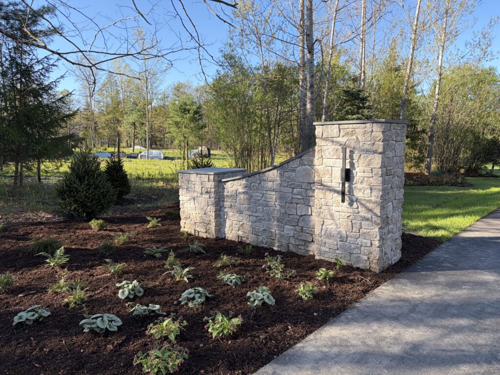 Austin Rustic Ashlar wing wall and pillar at residential driveway with landscape plantings