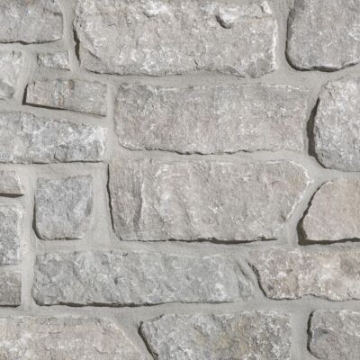 Aspen Ridge Stacked Stone thin veneer limestone close-up showing large-format creamy grey pieces with mortar joints