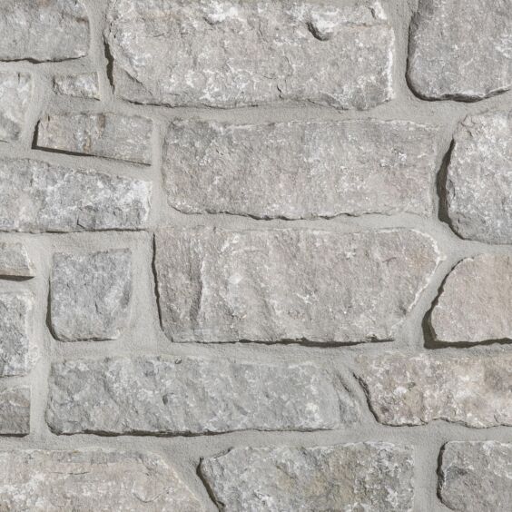 Aspen Ridge Stacked Stone thin veneer limestone close-up showing large-format creamy grey pieces with mortar joints