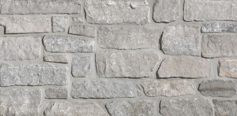 Aspen Ridge Stacked Stone thin veneer limestone close-up showing large-format creamy grey pieces with mortar joints