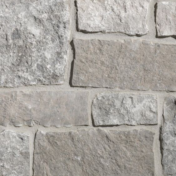 Aspen Ridge Sq & Rec thin veneer limestone close-up showing large square and rectangular pieces in creamy grey tones with mortar joints