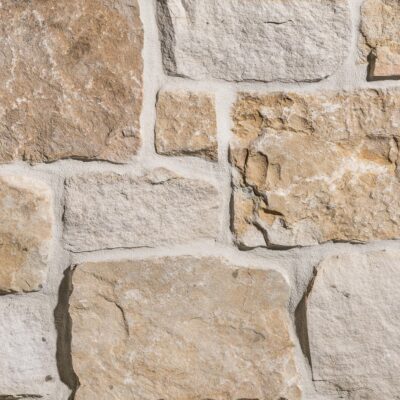 Heritage Buff Rustic Ashlar thin veneer close-up showing squared buff, honey, and golden brown sandstone stones with textured faces and mortar joints
